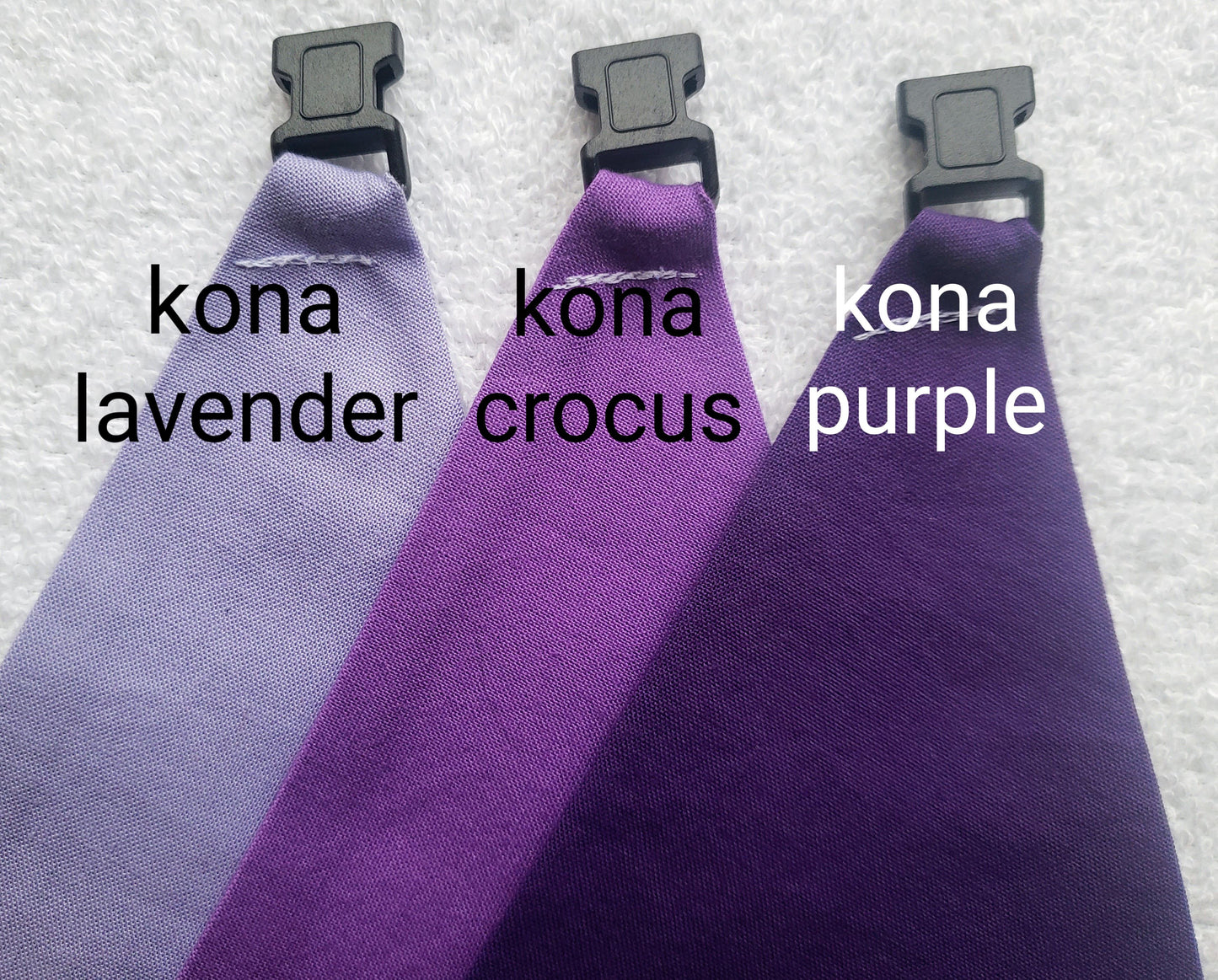 a group of three different colored ties on a white surface