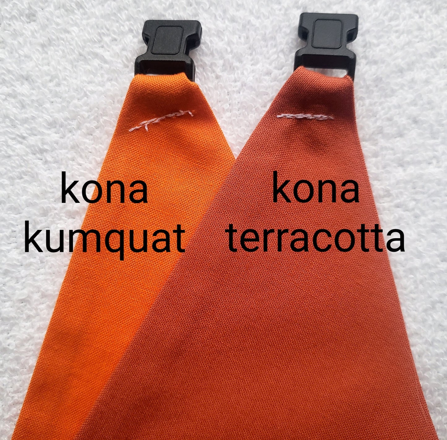 a couple of orange ties sitting on top of a white towel