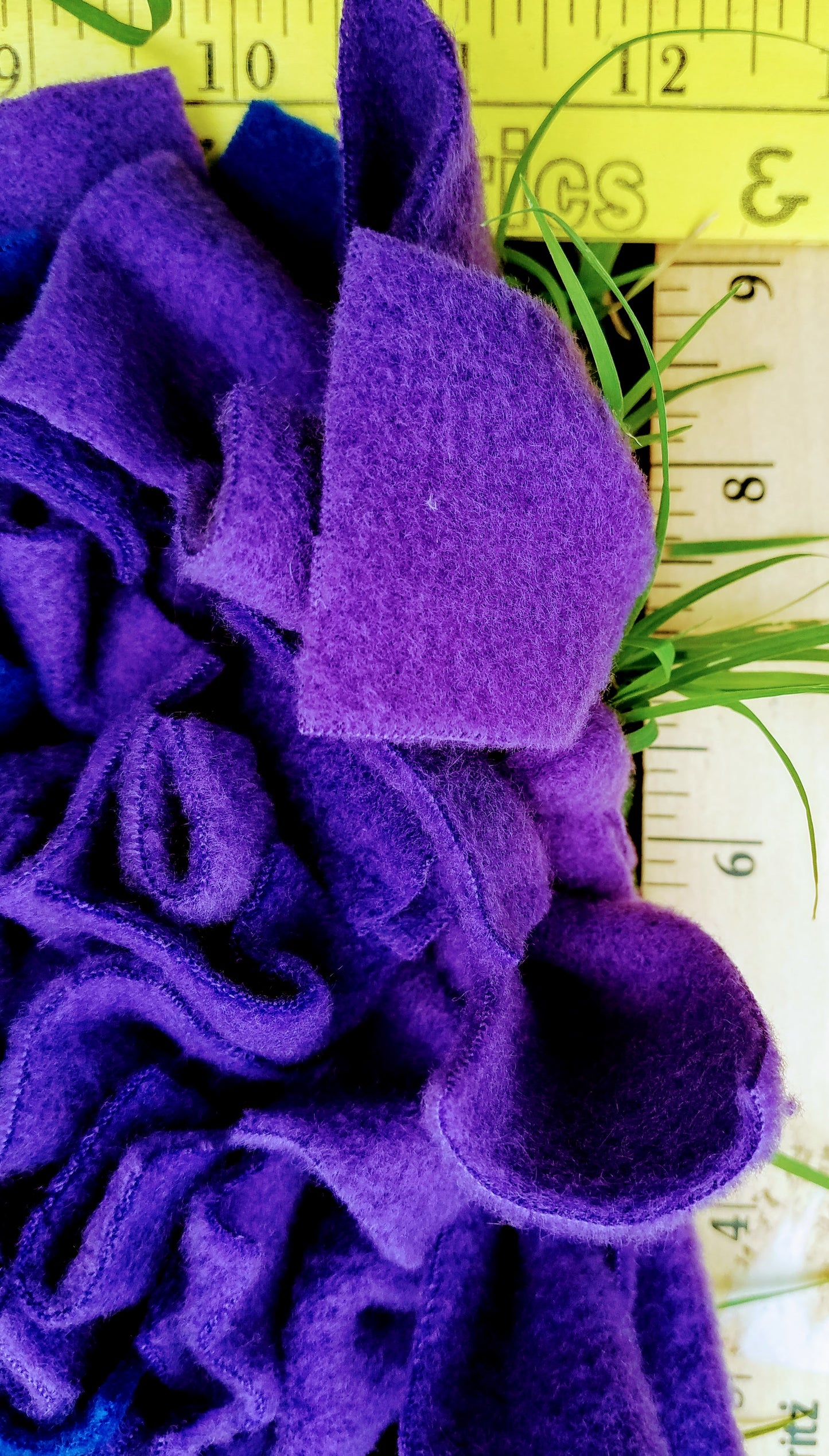 a close-up view of a pile of purple felt or fabric, with a ruler visible in the background.